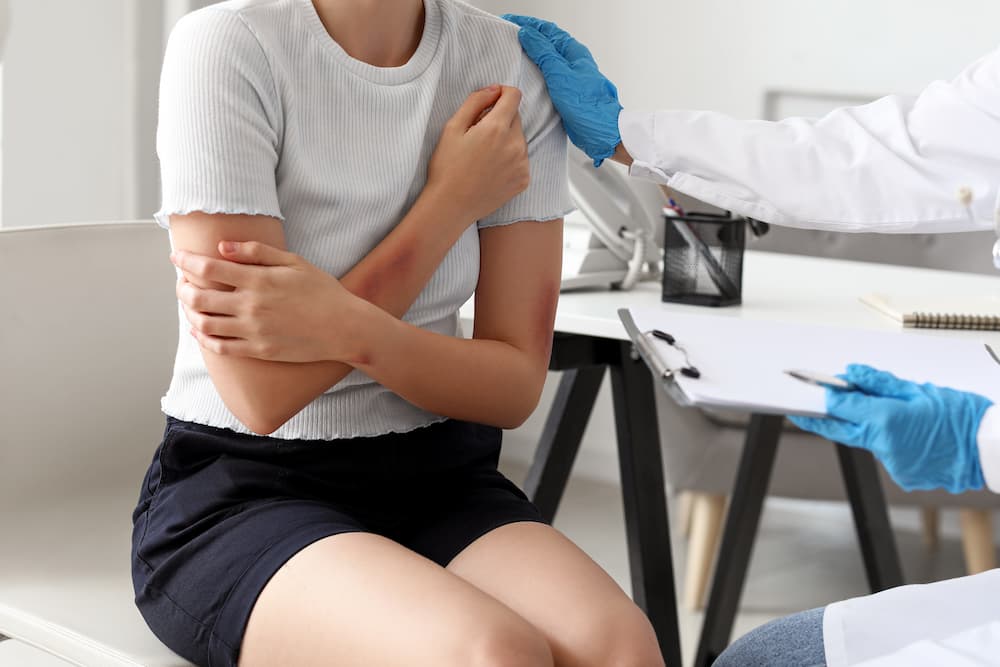 Patient receiving medical care for an arm injury during a clinic examination