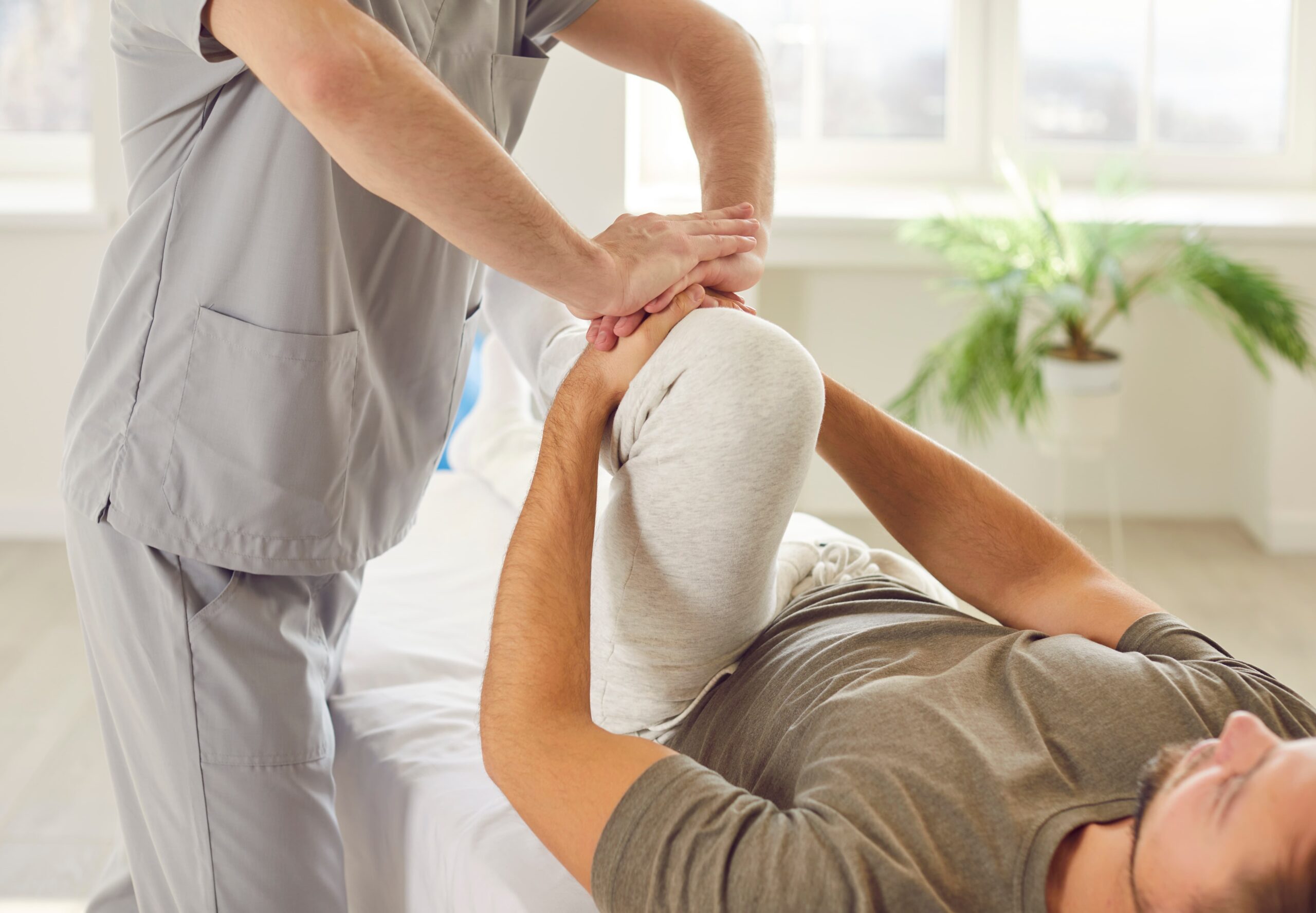 A man undergoing physical therapy by a medical professional